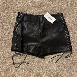 12th Tribe faux leather shorts with tie up sides. Size L. NWT.